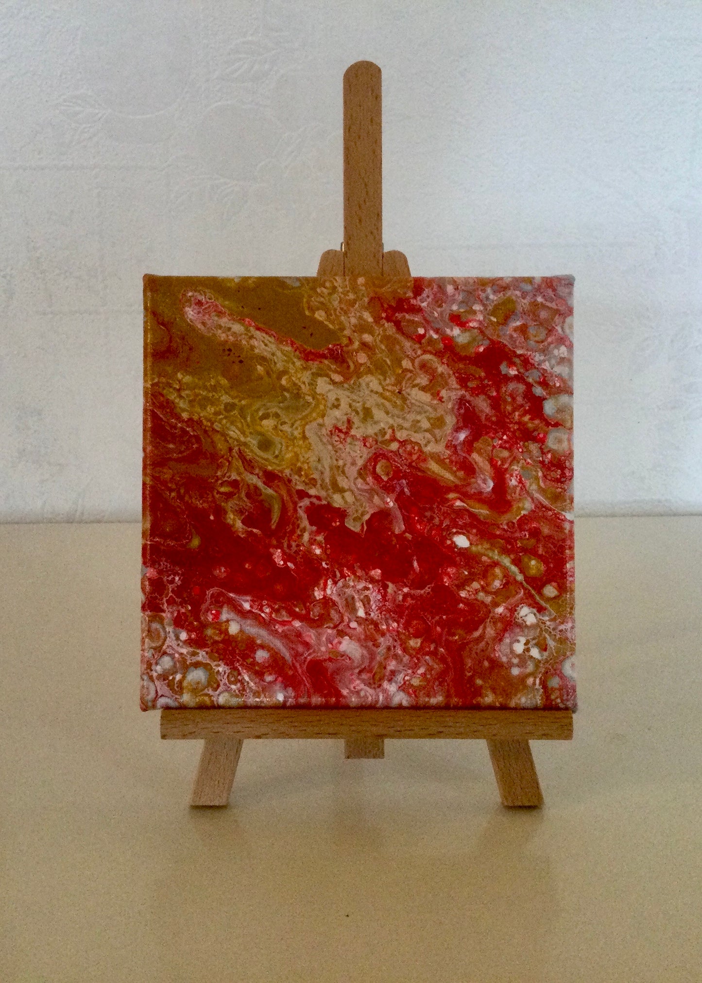 Acrylique pouring rouge ocre 15x15 sur chevalet